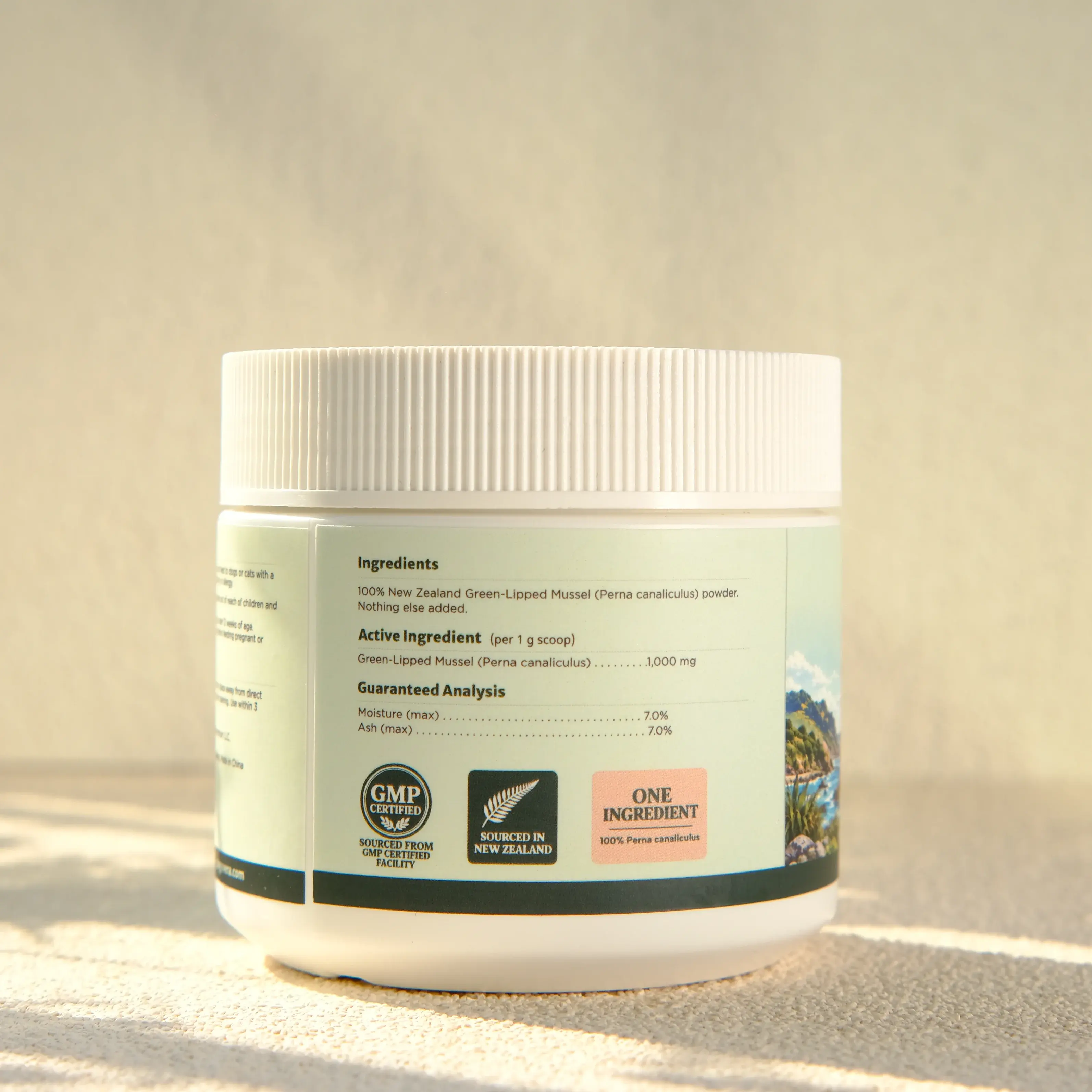 Ingredient panel on a jar of Dogevera green-lipped mussel powder: 100% New Zealand green-lipped mussel (Perna canaliculus) powder, nothing else added, 1,000 mg per 1 g scoop, with guaranteed analysis for moisture and ash.